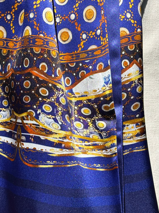 Detain of gold and white pattern on the Northumbria dark blue silk scarf by designer Anna Acciarini