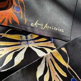 Close-up of fiery golden foliage design showing texture and designer signature in elegant silk finish