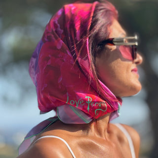 Model wears Love Peony Square Silk scarf, by Anna Acciarini, in bright sunshine