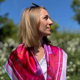 Side angle of the Love Peony Silk Scarf draped over a model’s shoulders, showcasing romantic pink and magenta peony details.