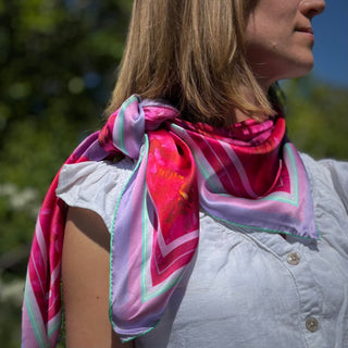Close-up of the Love Peony Silk Scarf knotted at the neck, displaying its rich palette of floral tones and luxurious silk texture.