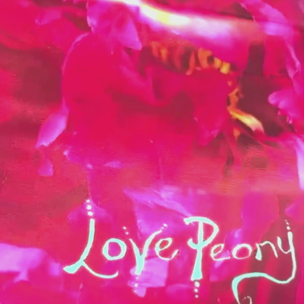 The Love Peony Silk Scarf in video, gently rippling to reveal vibrant peony design and the fluidity of the silk fabric. The words Love Peony are visible in a mint green.